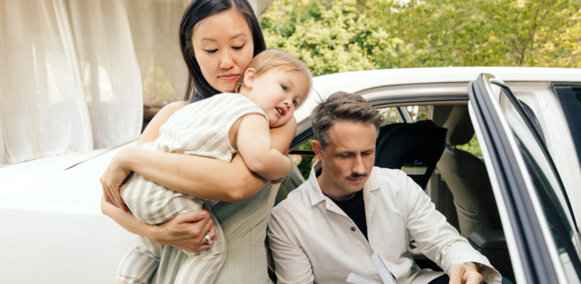 A woman holding a baby and a man holding a baby
