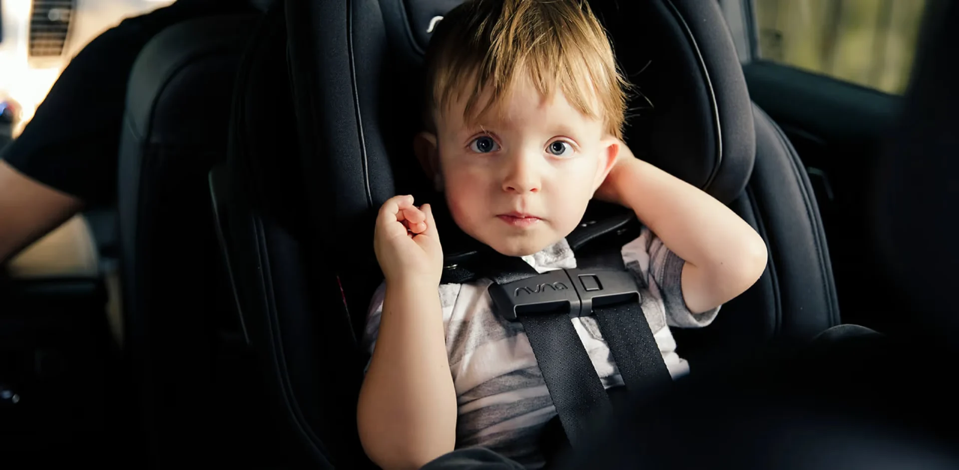 A little boy sitting in a car seat