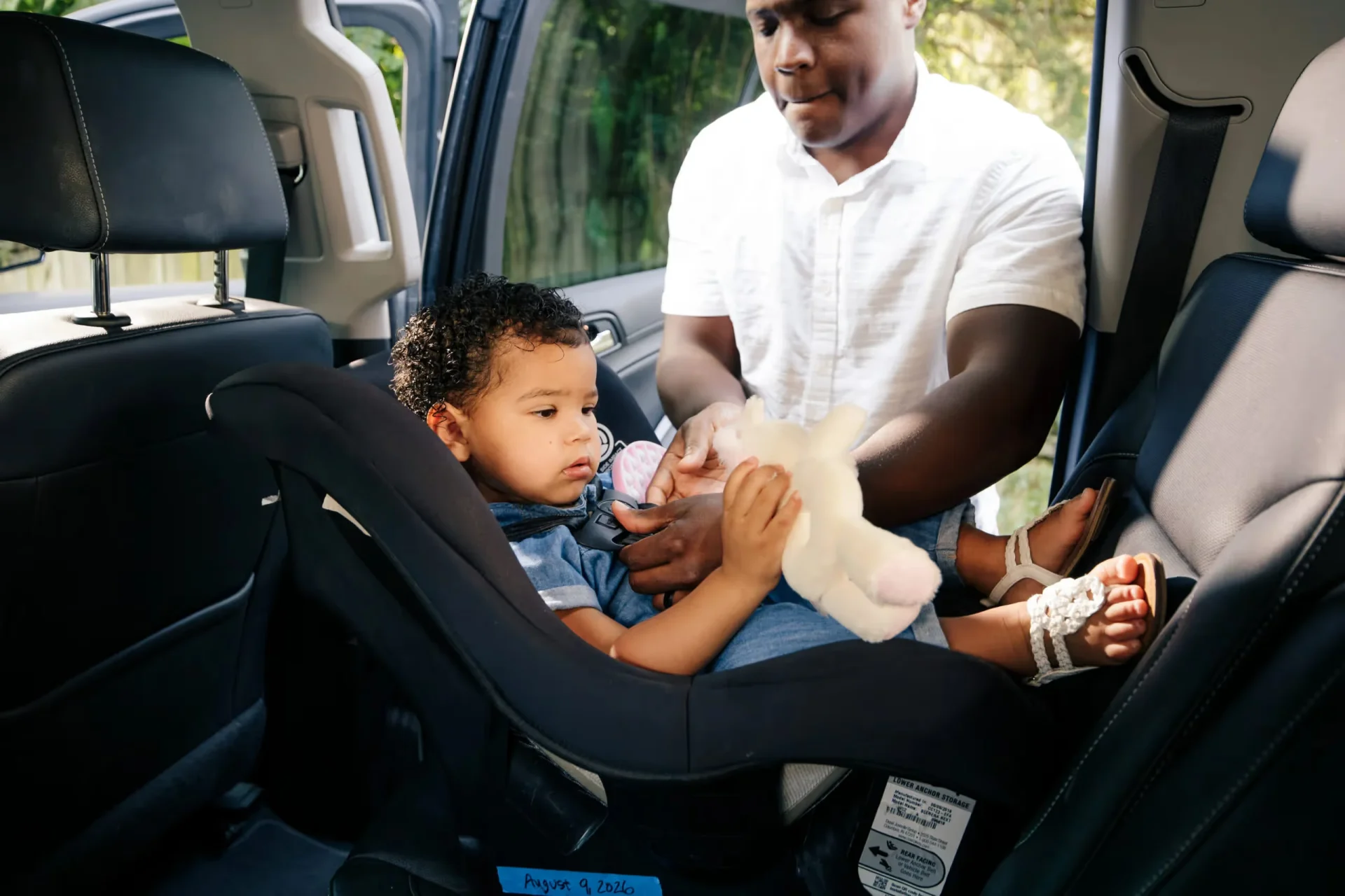 A man holding a baby in a car seat