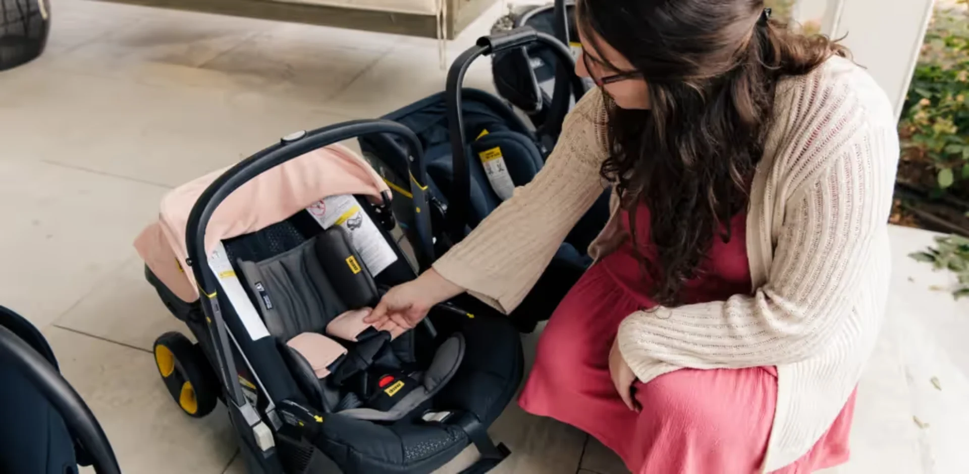 A woman sitting next to a baby in a stroller