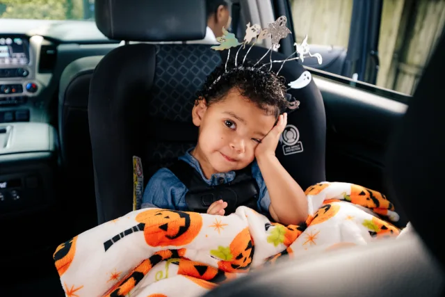 A little girl in a halloween costume holding a bucket