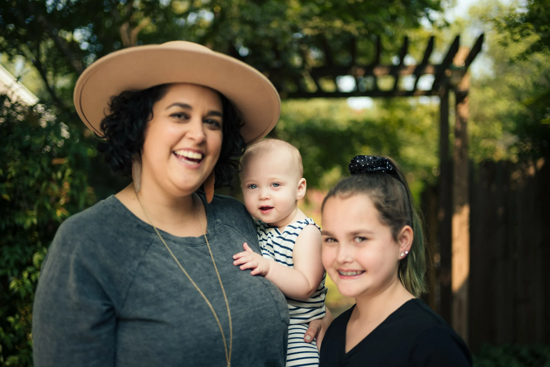 A woman holding a baby and smiling at the camera