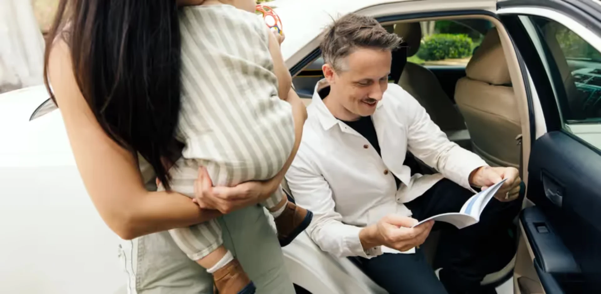 A man sitting in a car and a woman standing next to him