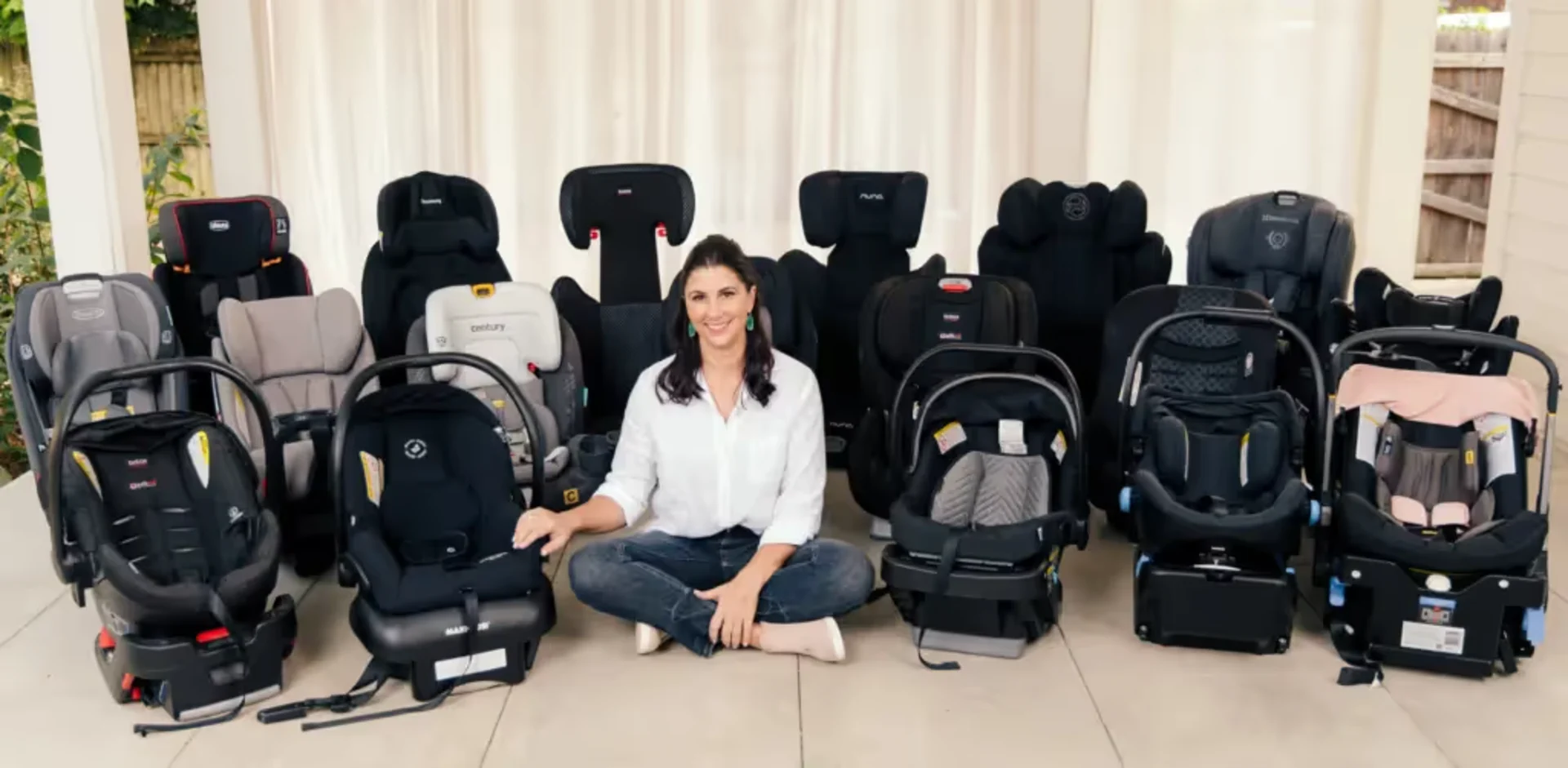 A woman sitting in front of a bunch of baby seats