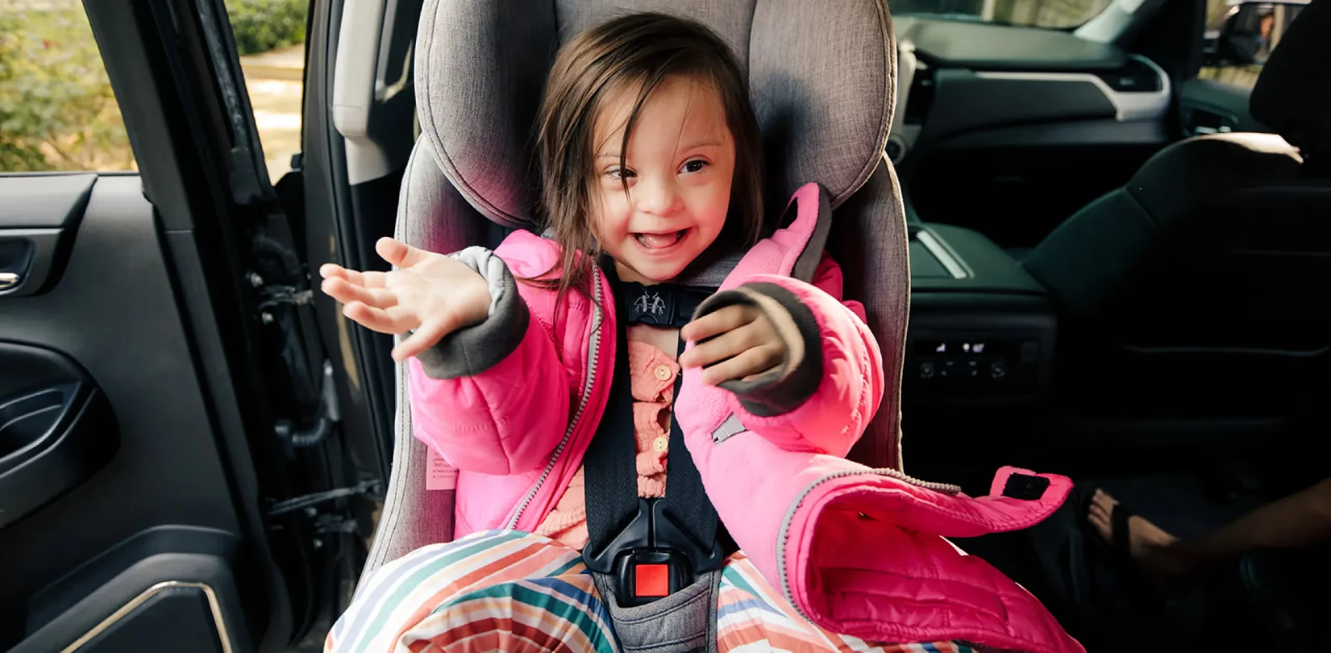 A little girl sitting in a car seat