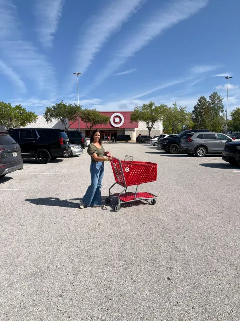 Woman with Target shopping cart full of car seats outside store entrance