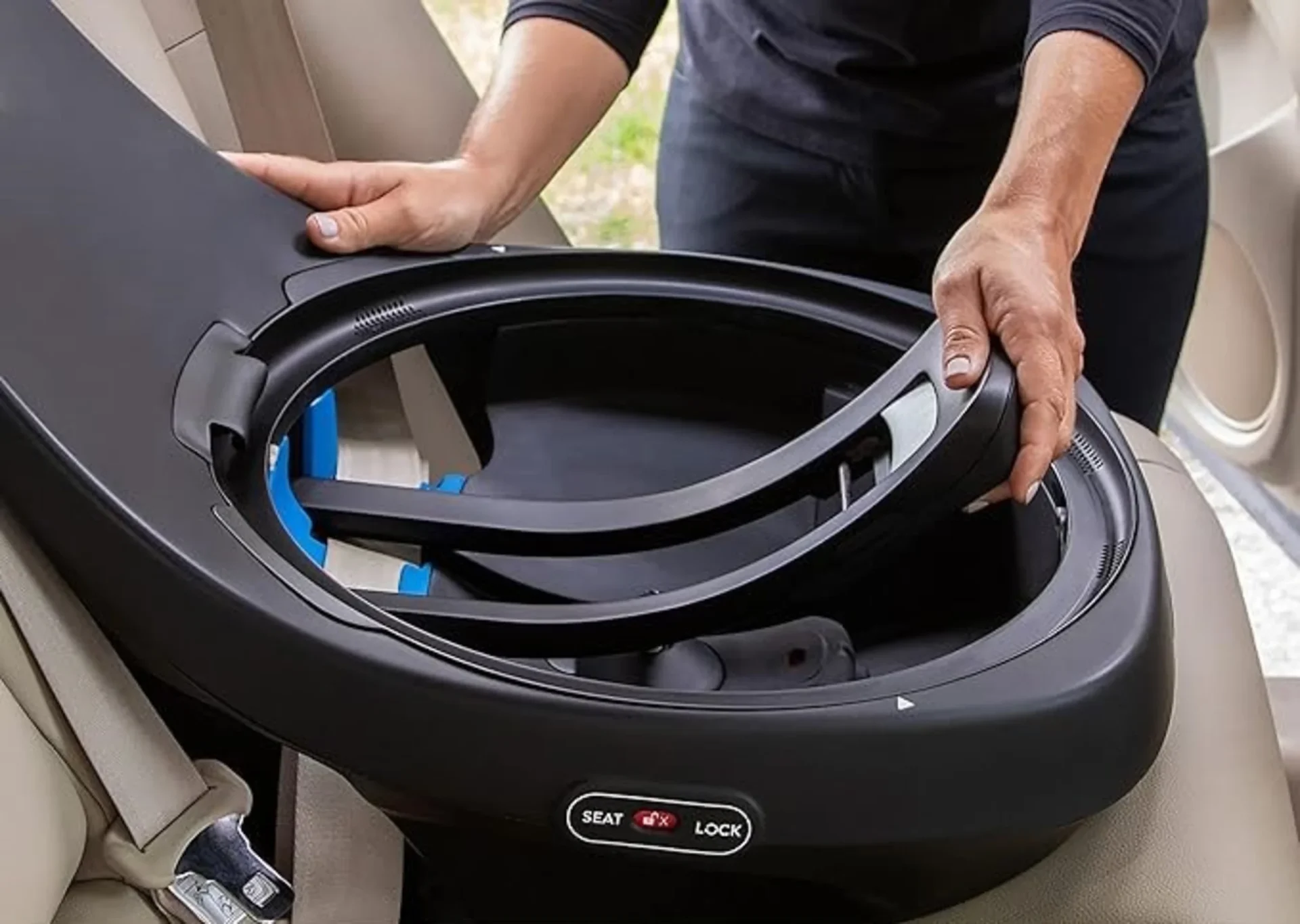 Person installing the Evenflo Revolve Slim rotating car seat base onto a vehicle rear seat showing the 360-degree swivel mech