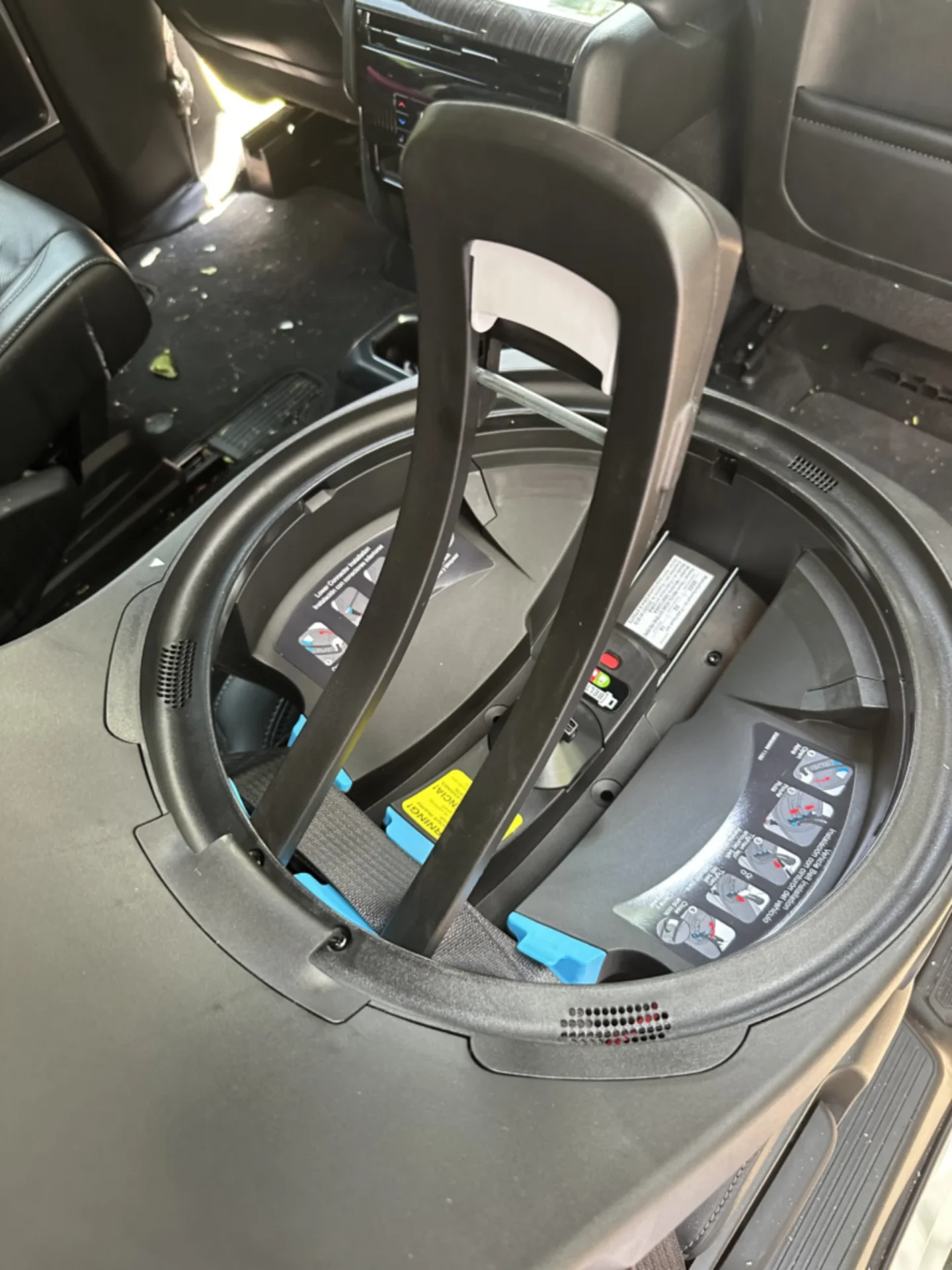 Evenflo Revolve Extend 360 rotating car seat base with blue LATCH connectors installed on vehicle floor viewed from above