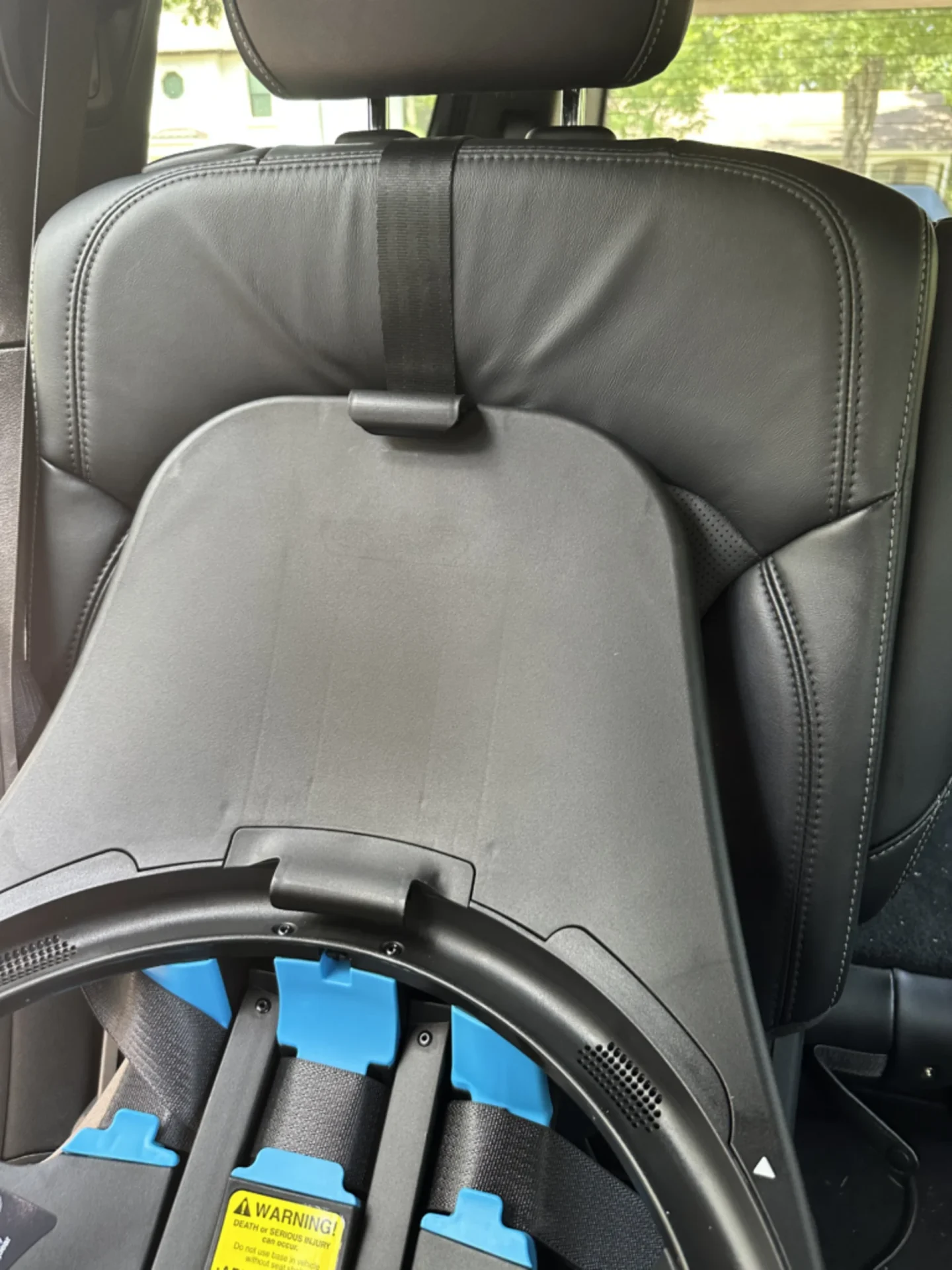 Evenflo Revolve Extend convertible car seat installed rear-facing on black leather vehicle seat with tether strap and blue LA