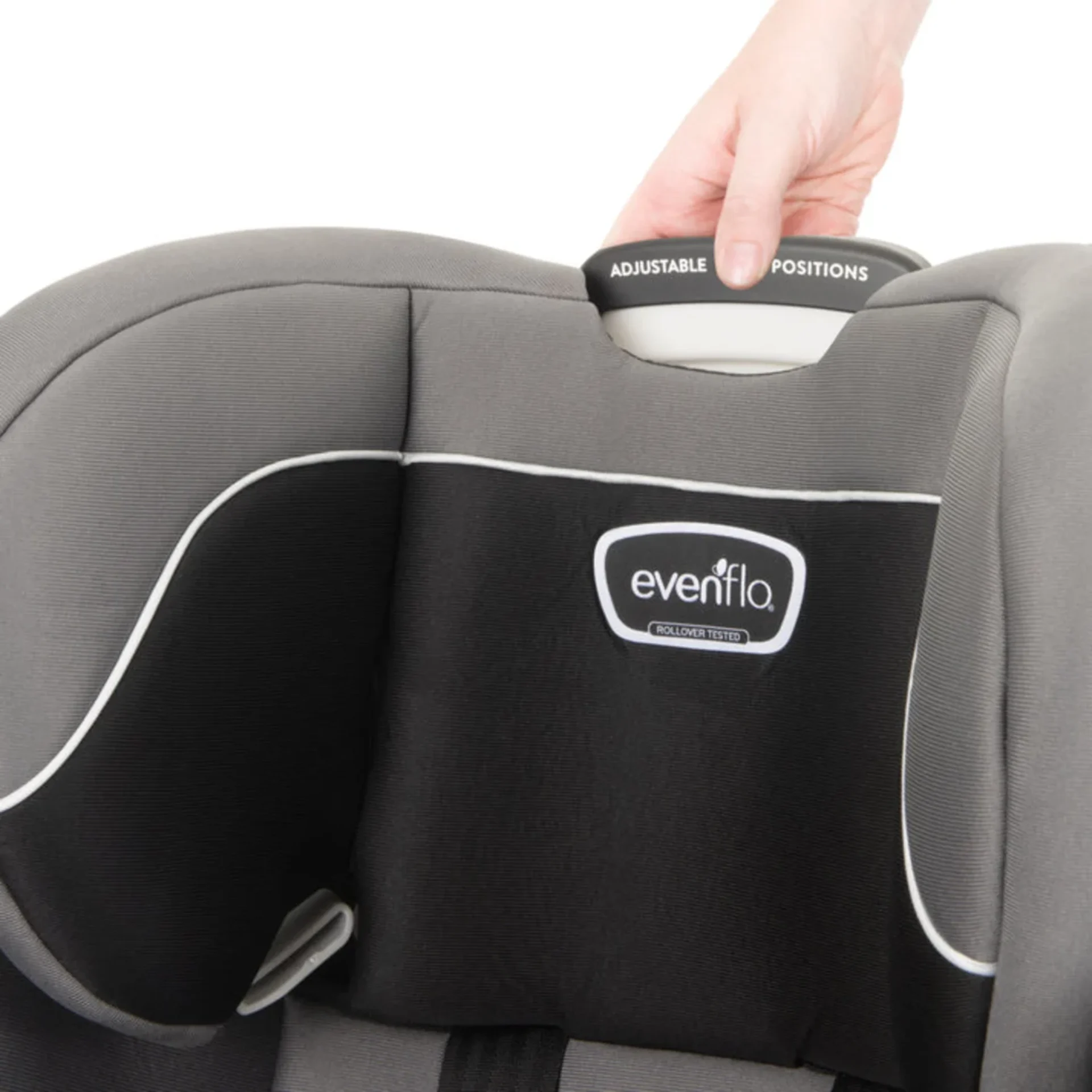Hand adjusting the multi-position headrest on an Evenflo Revolve car seat with rollover tested label visible