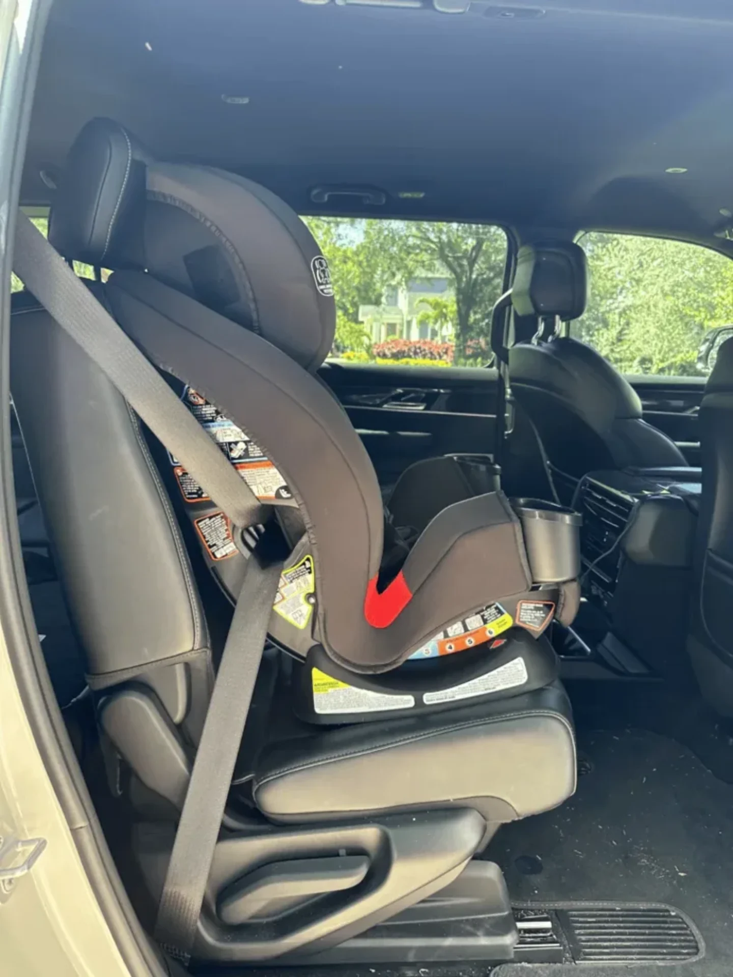 Graco TrioGrow SnugLock convertible car seat installed rear-facing in the back seat of a gold SUV with leather interior