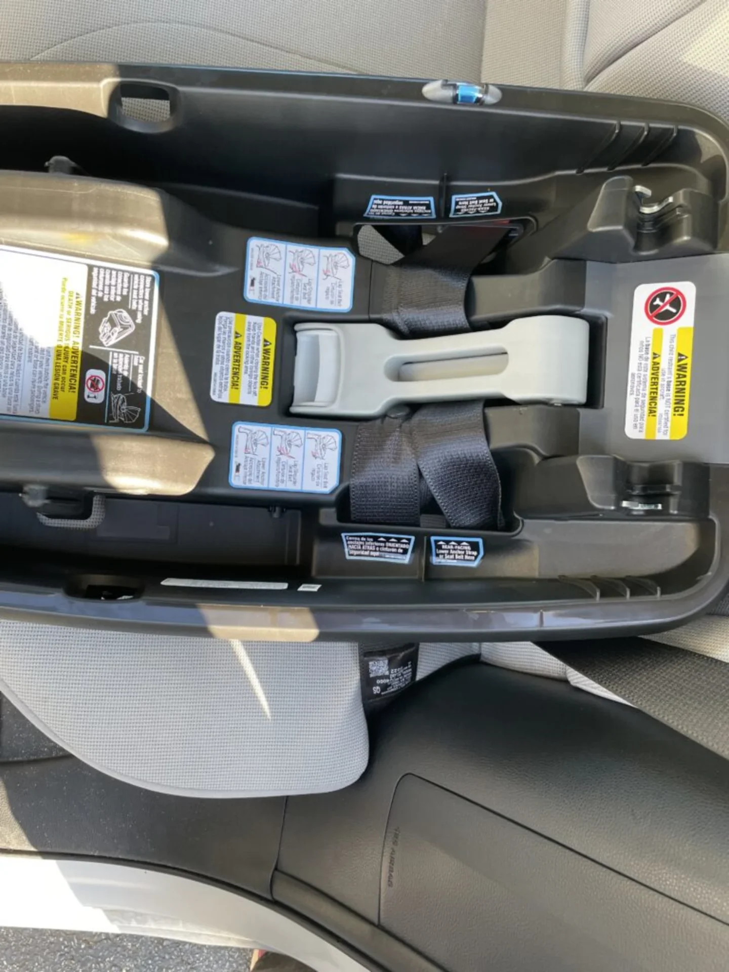 Graco SnugRide 35 DLX infant car seat base with load leg installed on gray vehicle back seat showing LATCH connectors and war