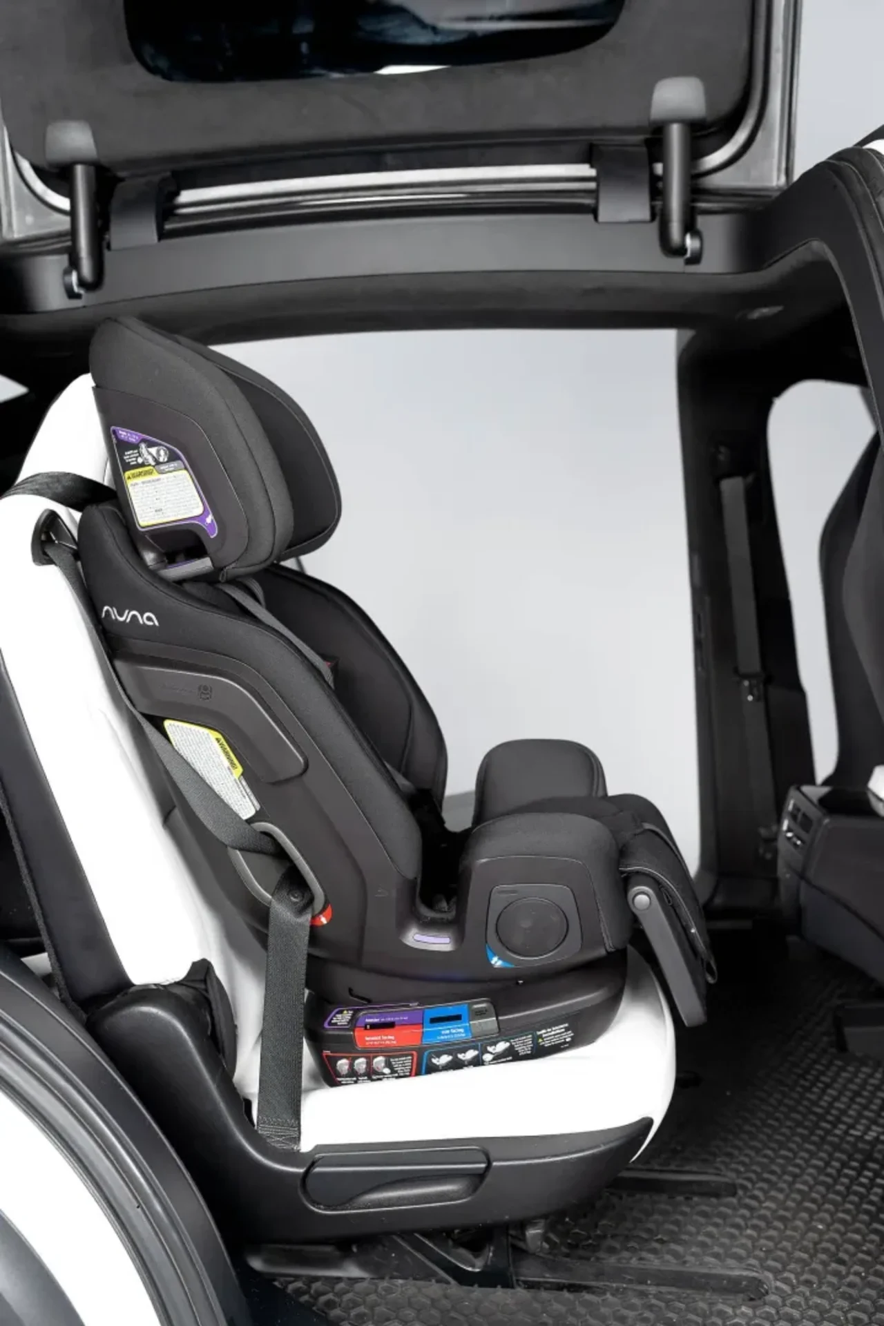 Nuna Exec black convertible car seat securely installed in a vehicle with safety labels and LATCH connectors visible