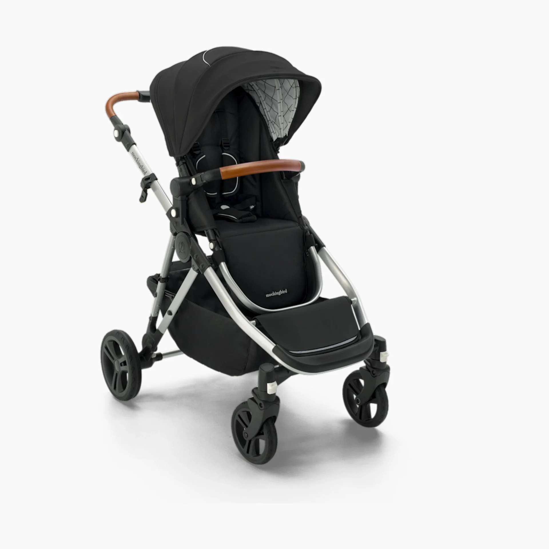 Mockingbird Single-to-Double Stroller in black fabric with silver aluminum frame and tan leather handlebar on white backgroun