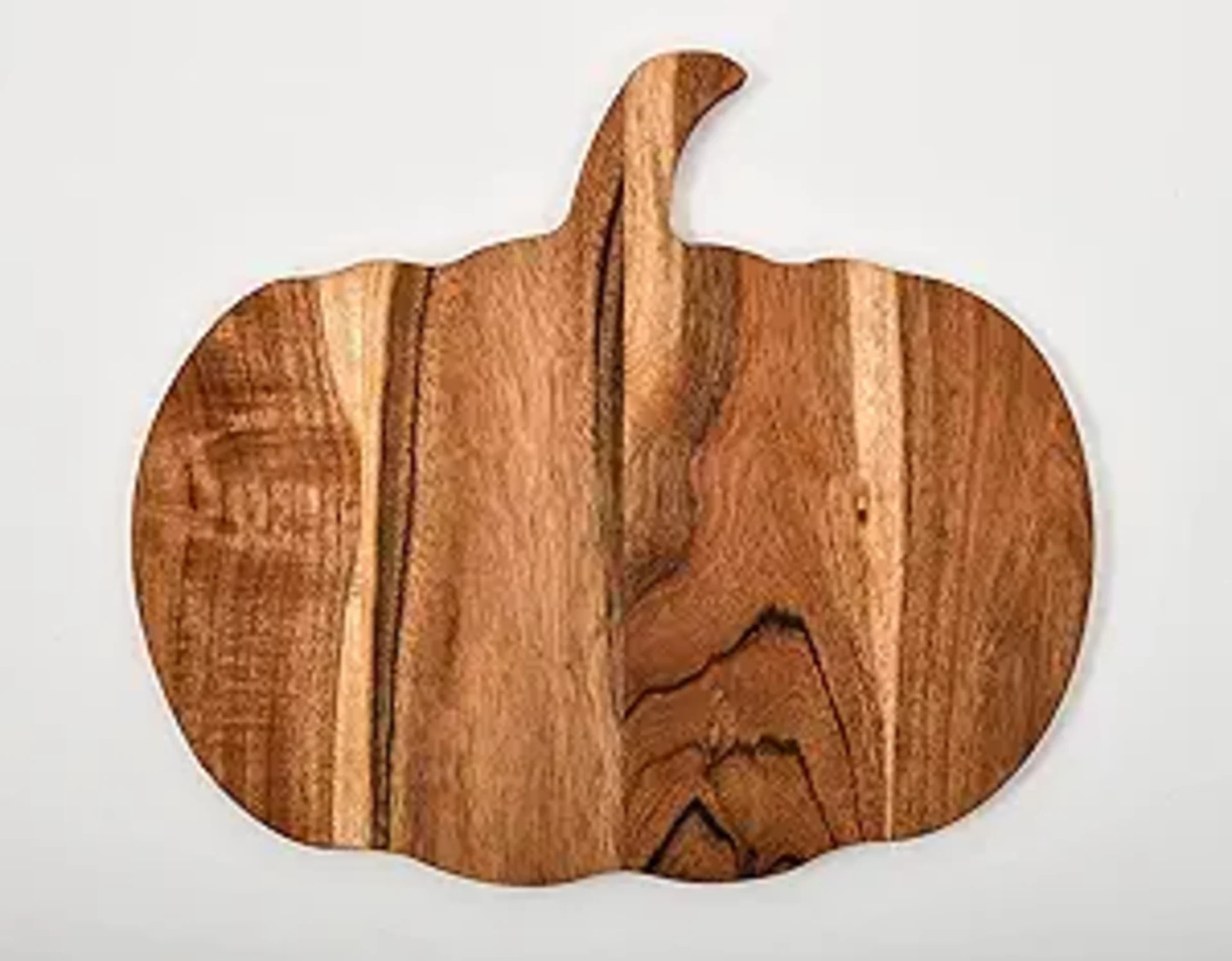 Pumpkin-shaped acacia wood cutting board with natural grain detail and curved stem on white background