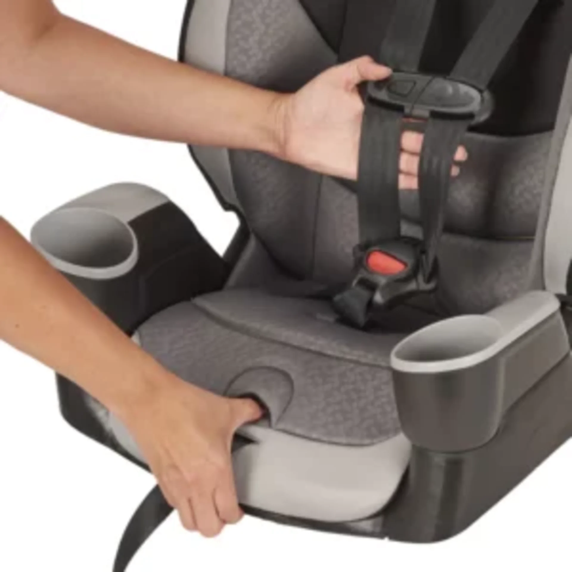 Adult hands adjusting the five-point harness buckle on a gray and black Evenflo Maestro Sport convertible car seat with cup h