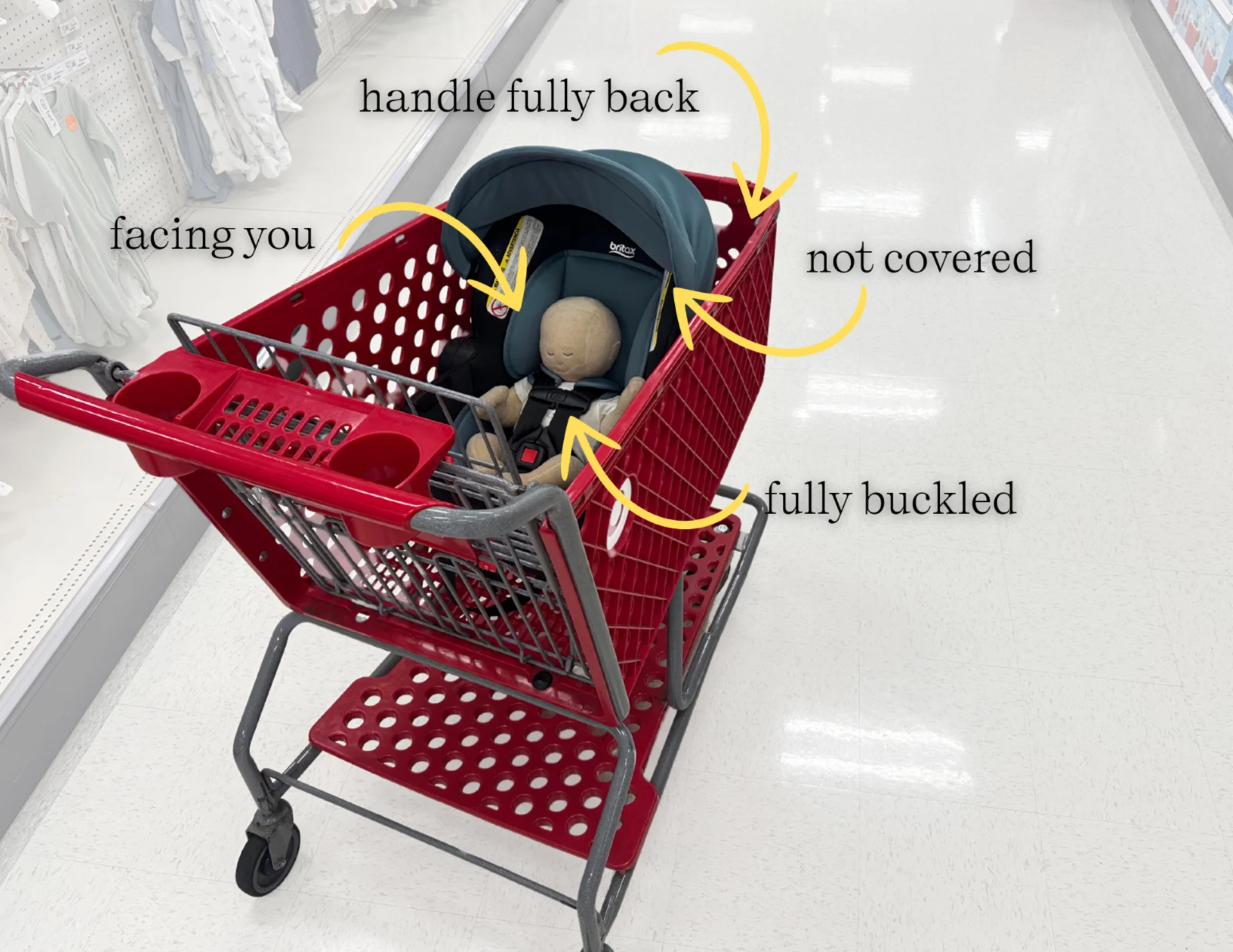 Britax infant car seat placed safely in a red Target shopping cart facing parent, handle back, baby buckled, canopy open, wit