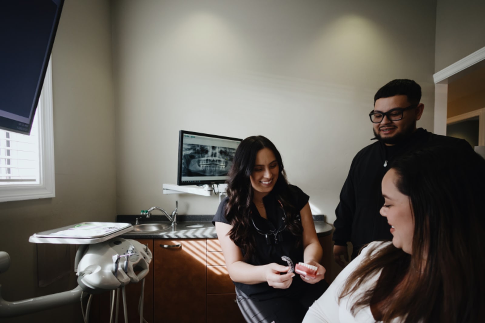 Dentist discussing treatment with female patient in clinical setting