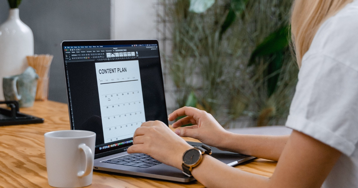 Person creating a social media plan and content calendar on a laptop.