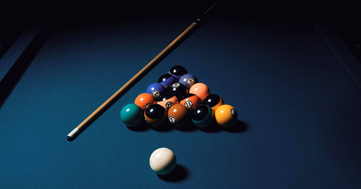 Pool table with billiard balls illustrating how a social media strategy aligns business goals and target audience.