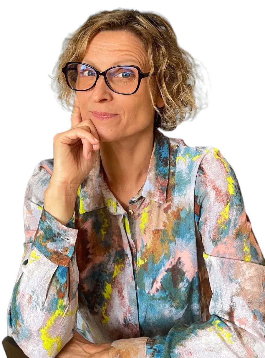 Foto von Sandra Holze in einer nachdenklichen Pose mit einer bunten Bluse