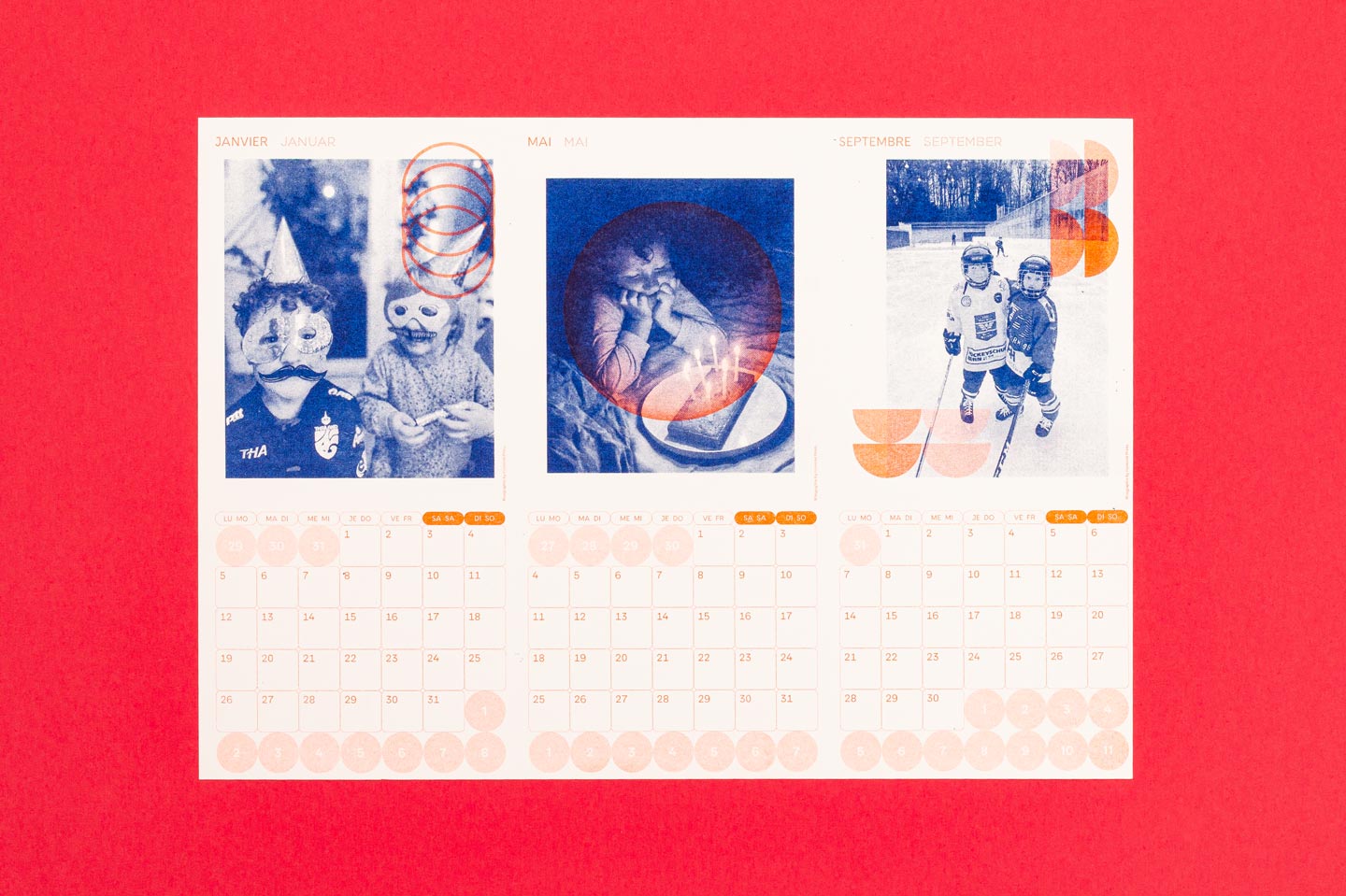 Ein bunter Kalender zeigt verspielte Bilder von Kindern mit Masken, beim Kuchenessen und beim Schlittschuhlaufen, umgeben von lebhaften geometrischen Formen. Der Kalender wurde im Risographieverfahren gedruckt.