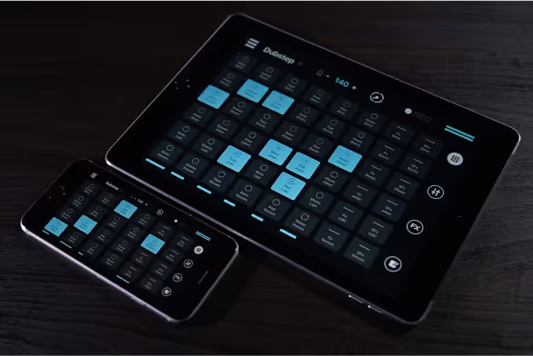 Early version of the Remixlive app displayed on a smartphone and a tablet, showing a grid of sound pads labeled with different samples. The interface includes controls for recording, playback, and effects, demonstrating the app's functionality for creating and mixing music on multiple devices.