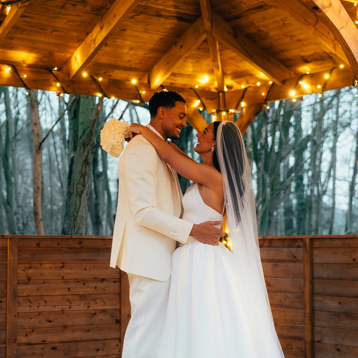 Newlyweds beneath the lit gazebo at dusk at Blackbrook Barns, Lichfield, Staffordshire