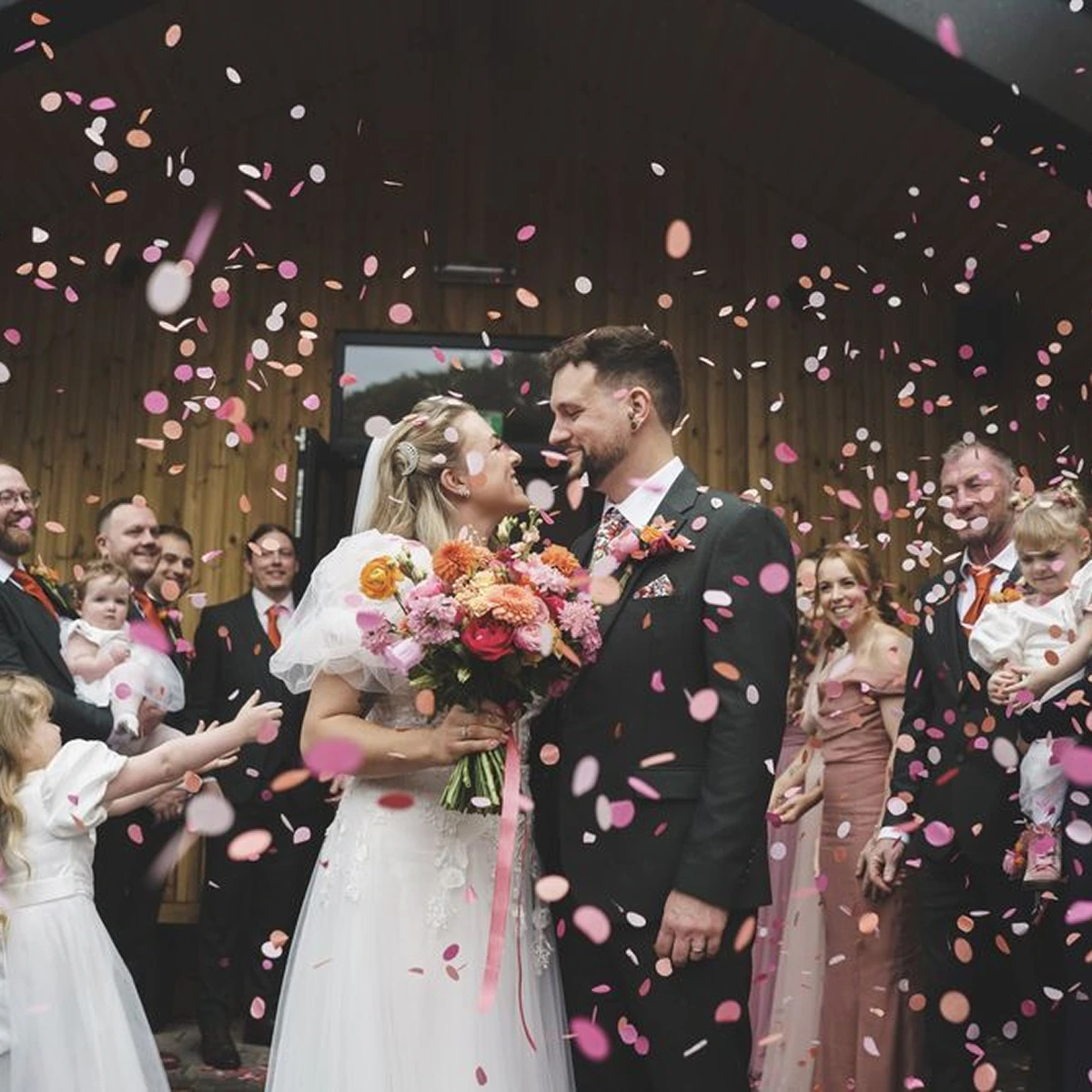 Confetti falling around newlyweds after their ceremony at Blackbrook Barns, Lichfield, Staffordshire