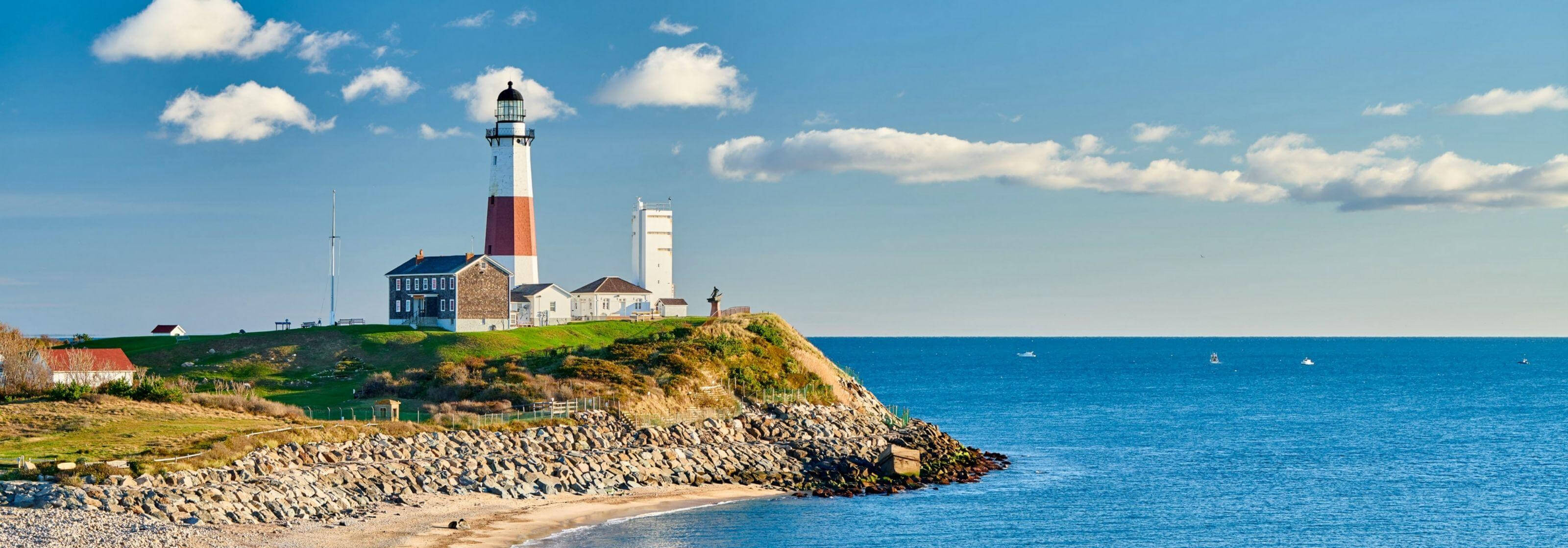 A lovely lighthouse sitting on the a cliff peak.
