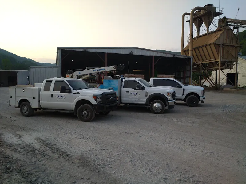 Mobile fleet service trucks parked outside a heavy-duty repair facility, ready to provide on-site maintenance and repair services.