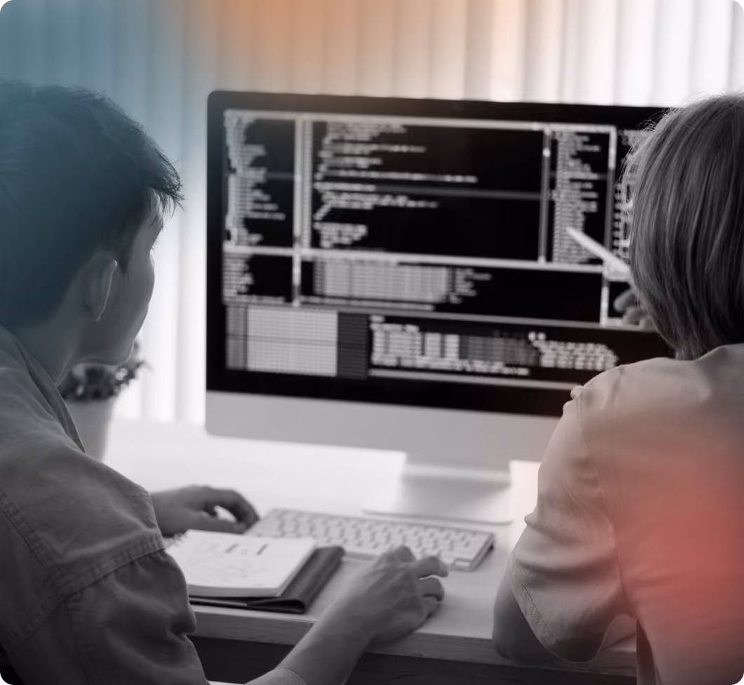 Man and woman looking at screen with code
