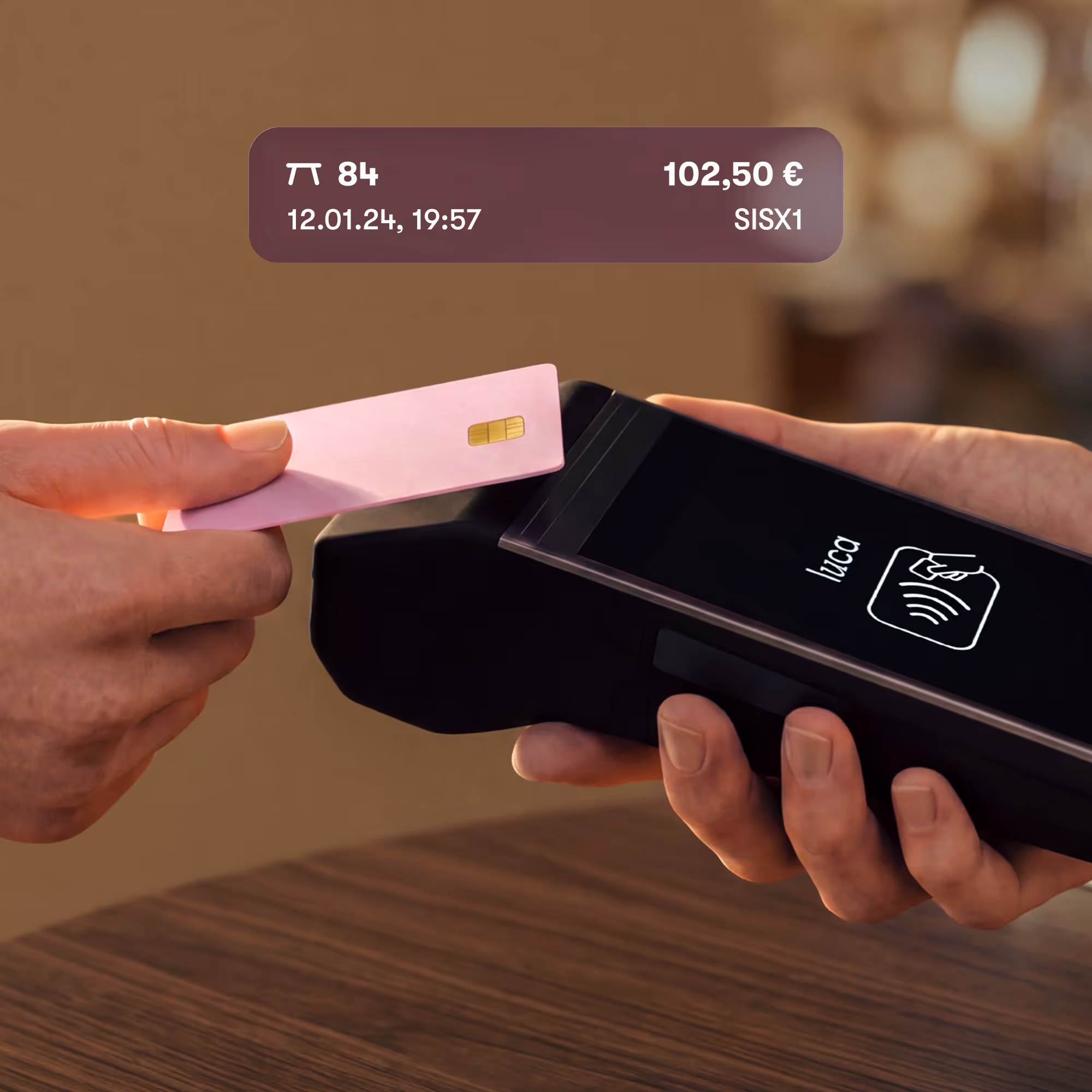 Kontaktloses Bezahlen einer rosa Kreditkarte an einem mobilen Kartenlesegerät namens luca.