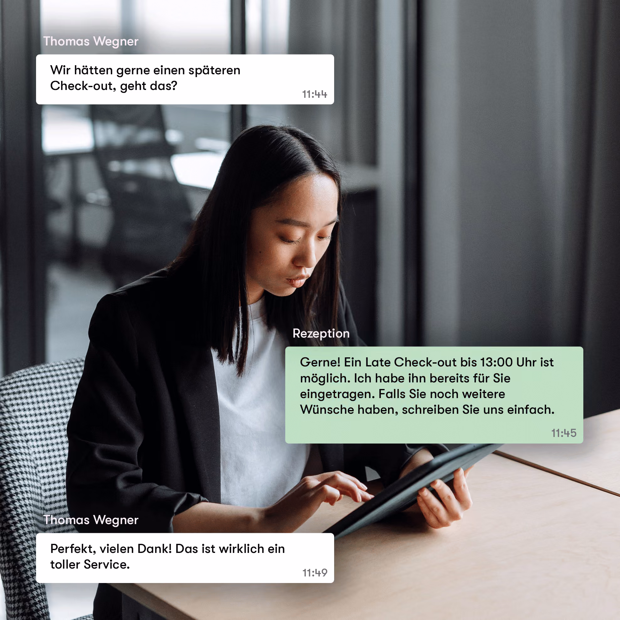 Junge Frau mit schwarzem Blazer sitzt an einem Tisch und tippt auf einem Tablet, daneben sind Chat-Nachrichten in Deutsch über einen späten Check-out zu sehen.