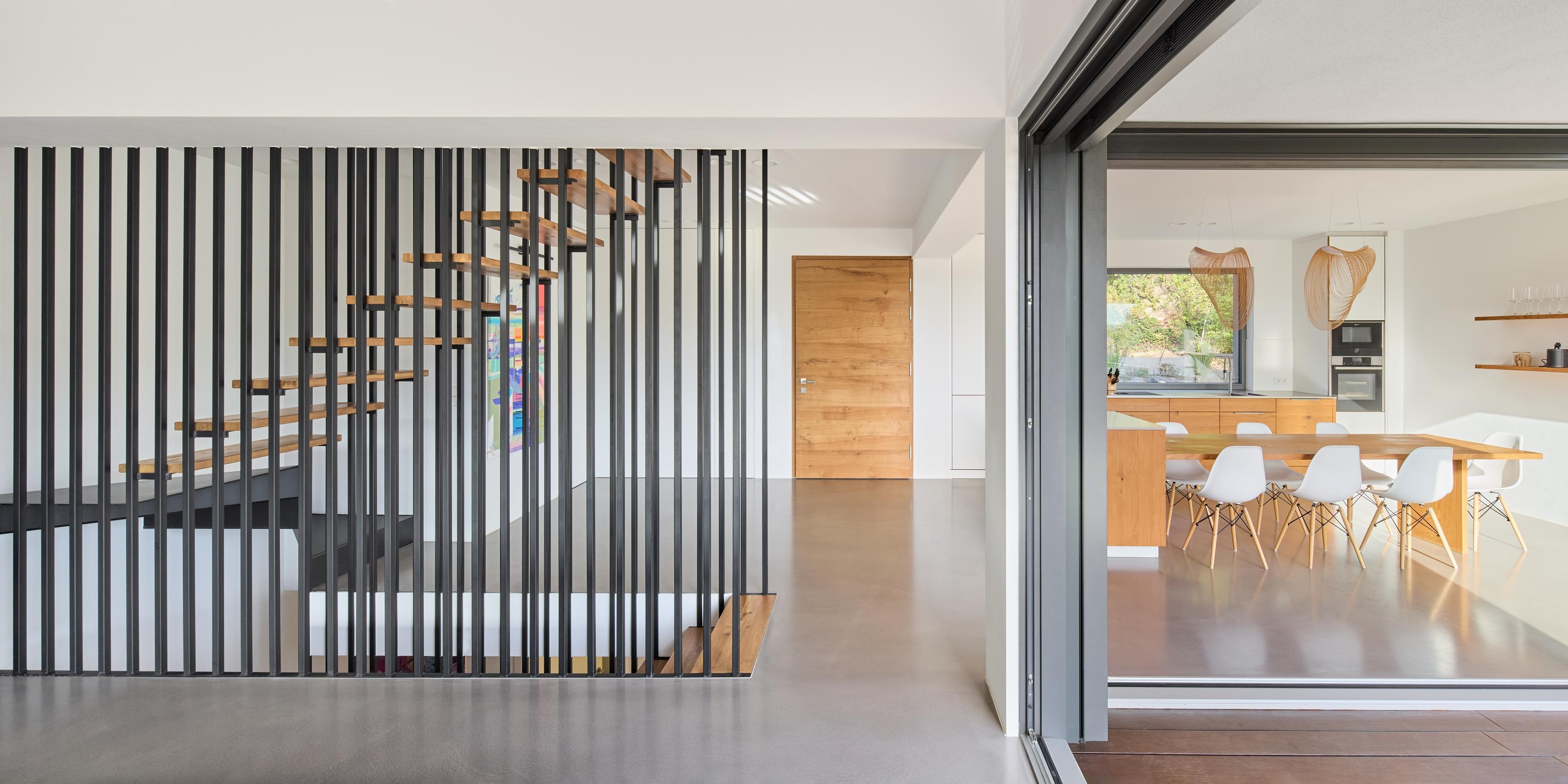 there is a staircase in the middle of a room with a table and chairs