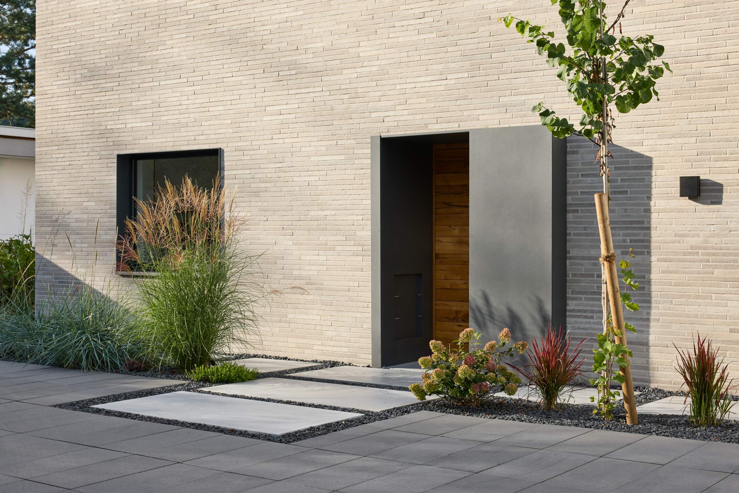 there is a small tree in front of a building with a door