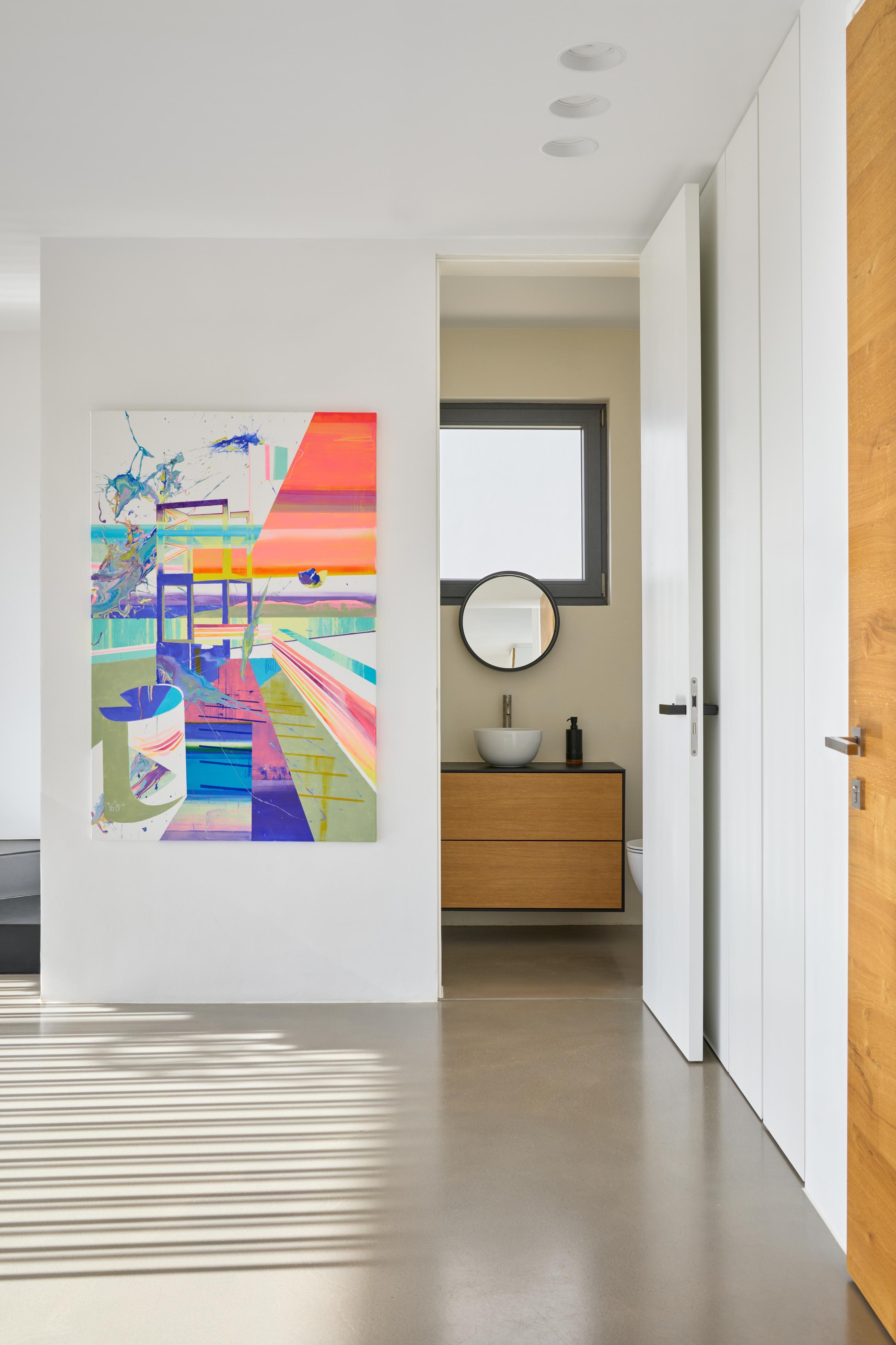 there is a painting on the wall in a hallway next to a bed