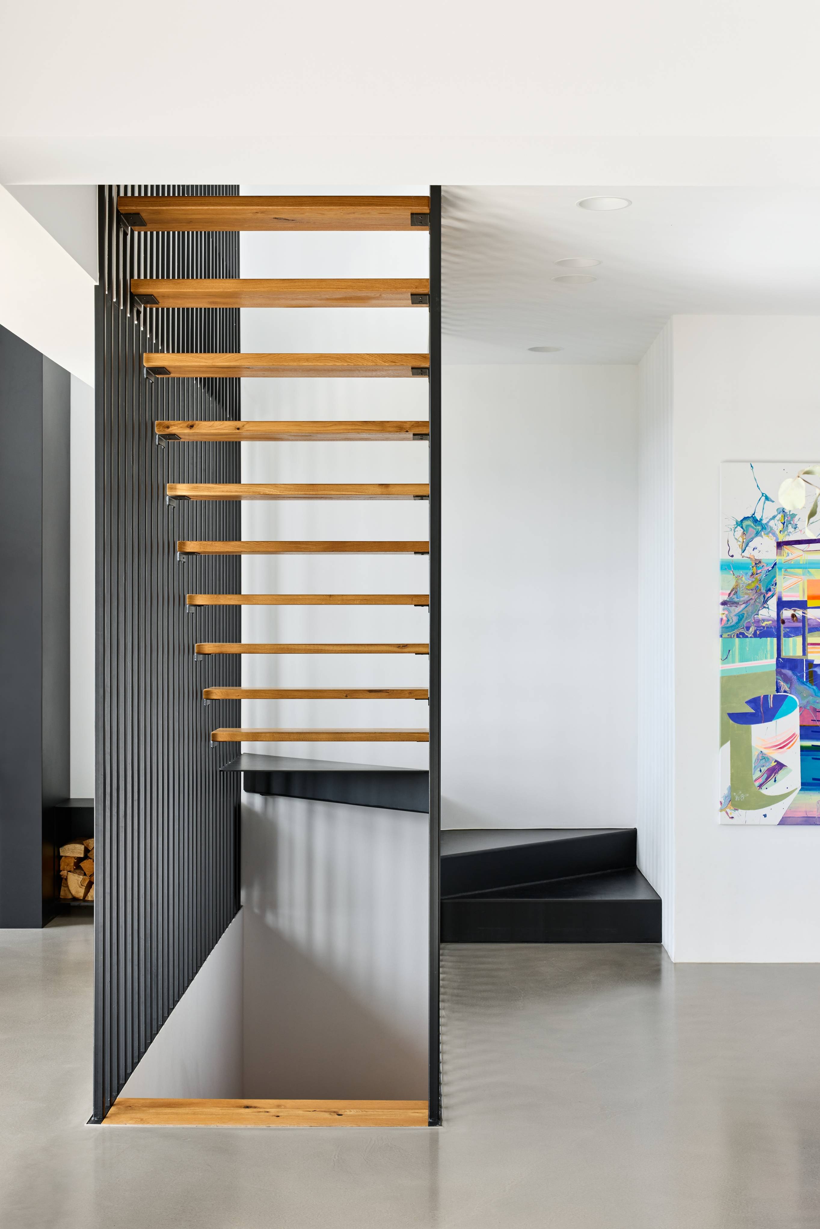 there is a staircase in a room with a painting on the wall