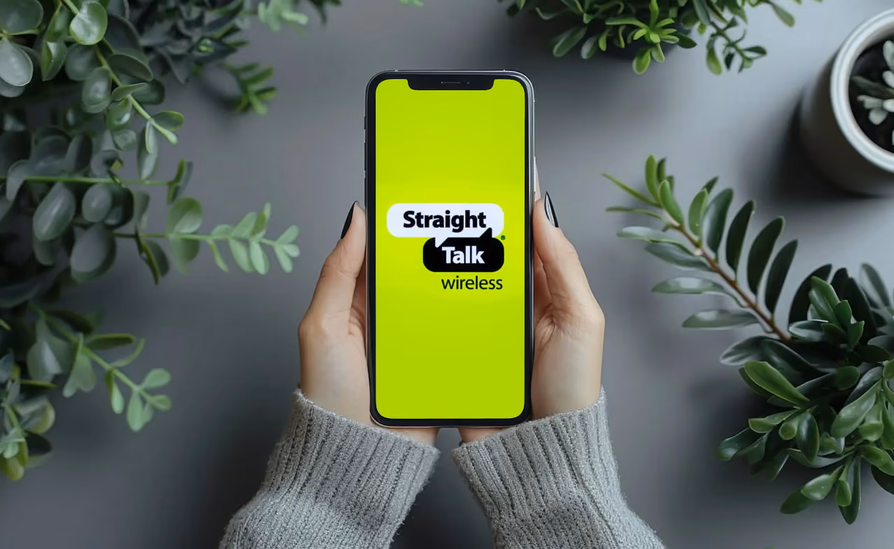 A person holding a smartphone with Straight Talk logo on the screen