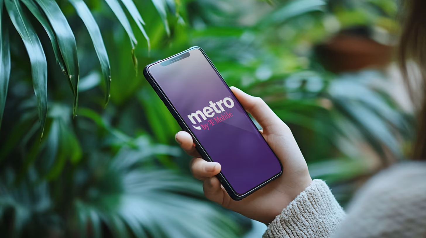 A person holding a smartphone with metro by t-mobile logo on the screen