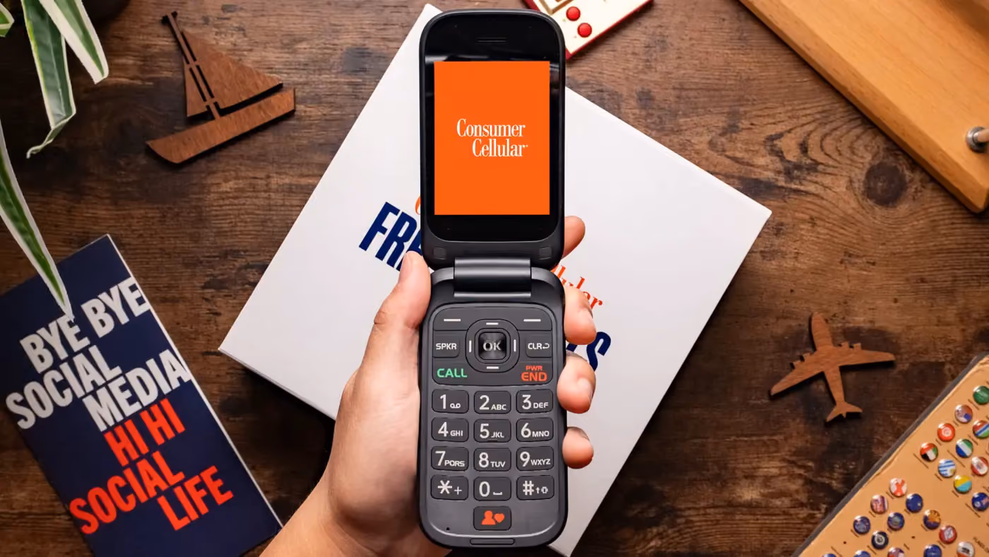 Hand holding phone with consumer logo on the screen