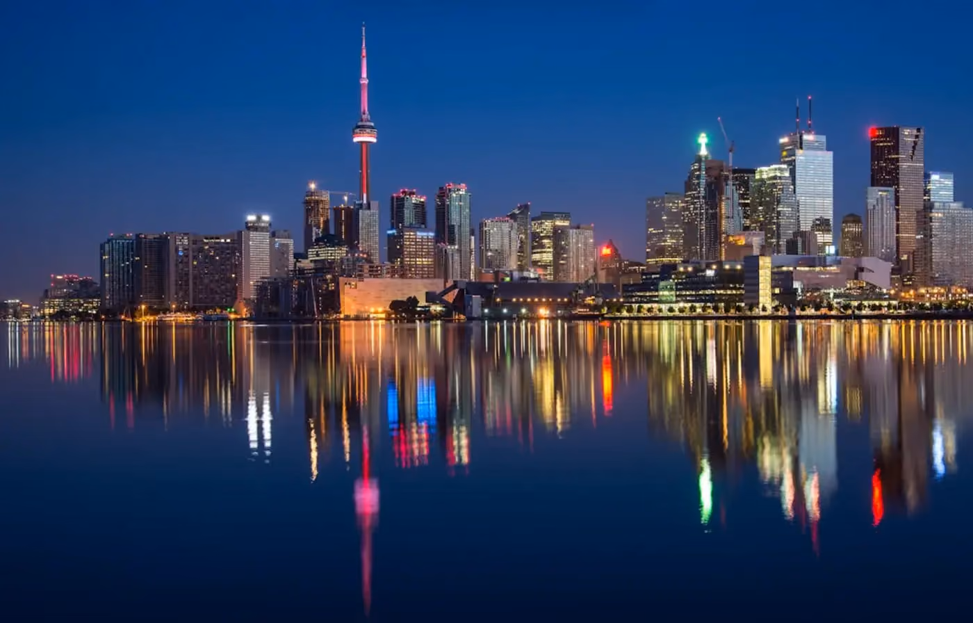 a city skyline with lights reflecting on water