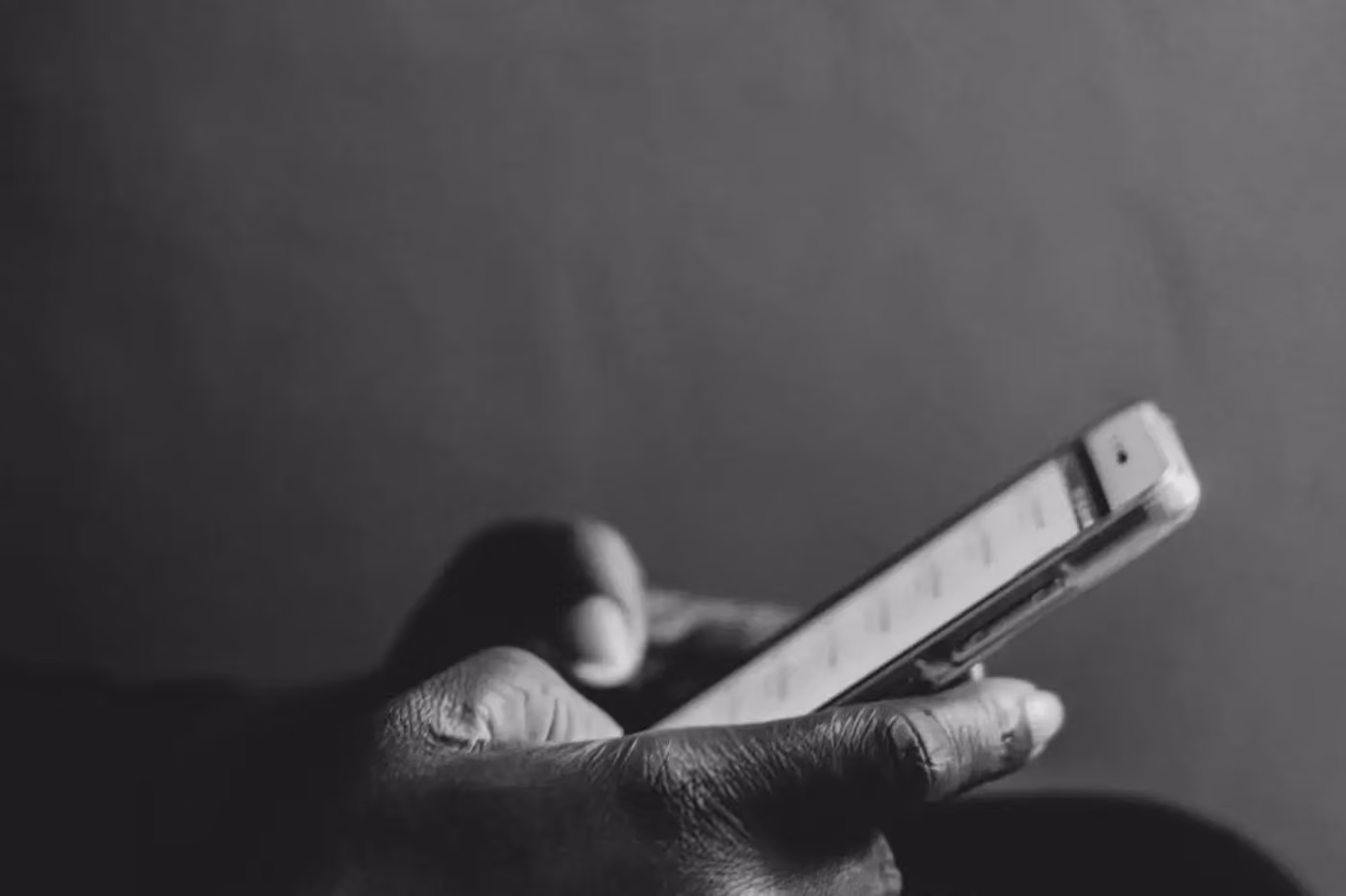 a person holding a cell phone, black and white