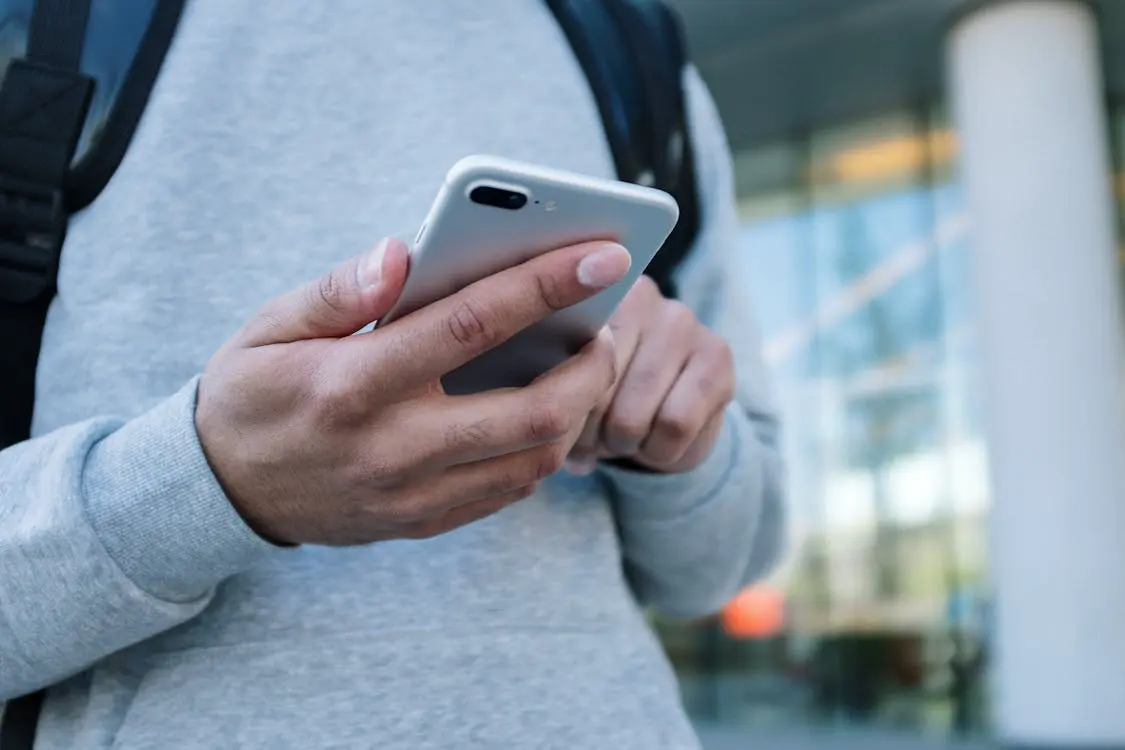 Free Person in Gray Long Sleeve Shirt Holding Silver Iphone 6 Stock Photo