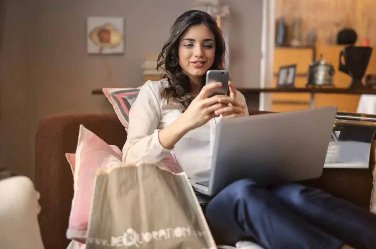a person sitting on a couch using a laptop