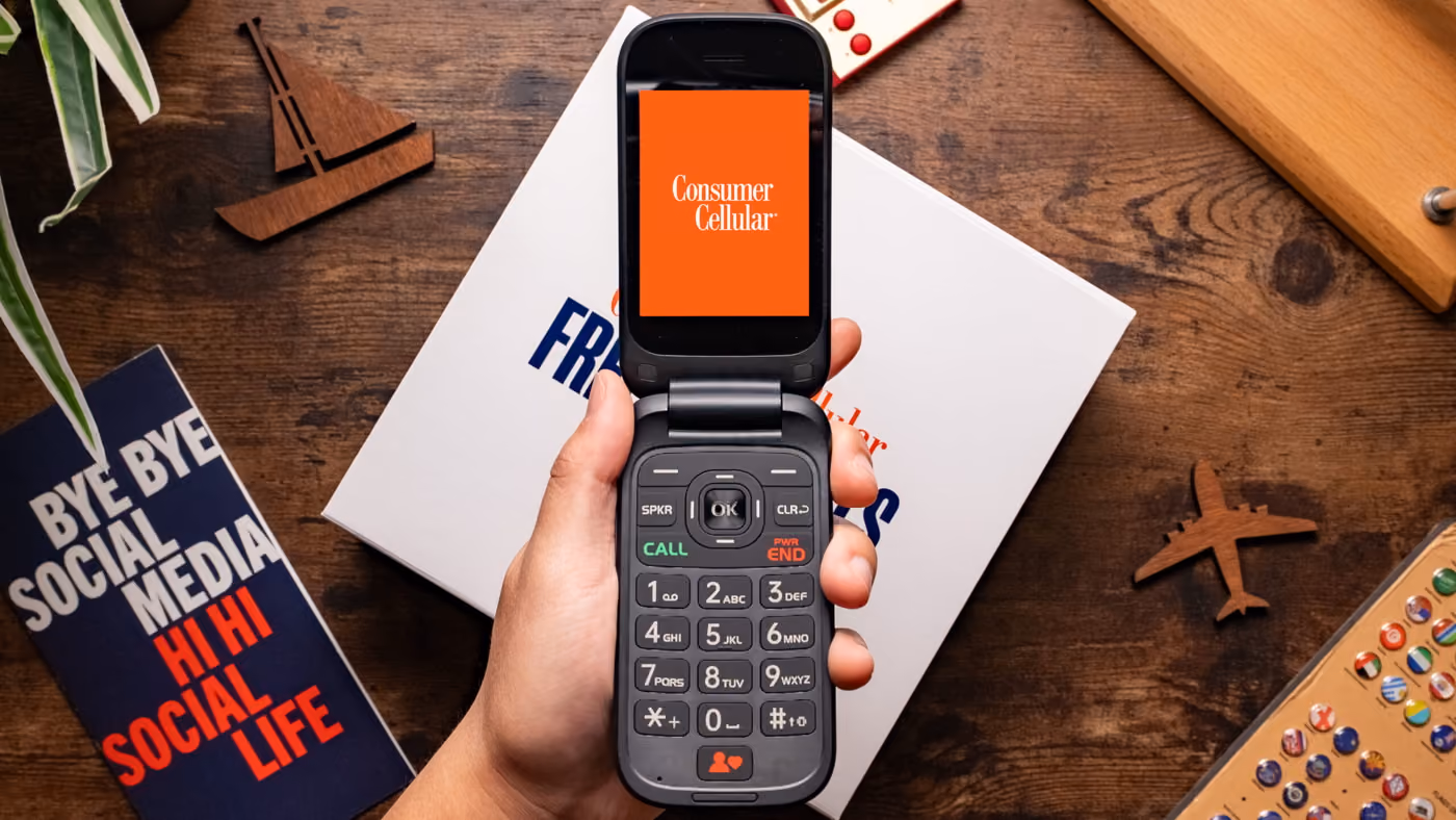 A hand holding phone with consumer cellular phone