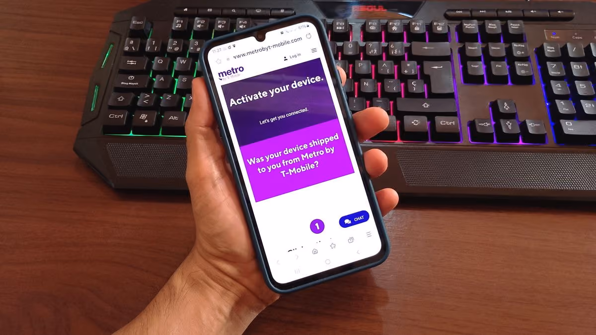 A person holding a smartphone with metro by t-mobile logo on the screen