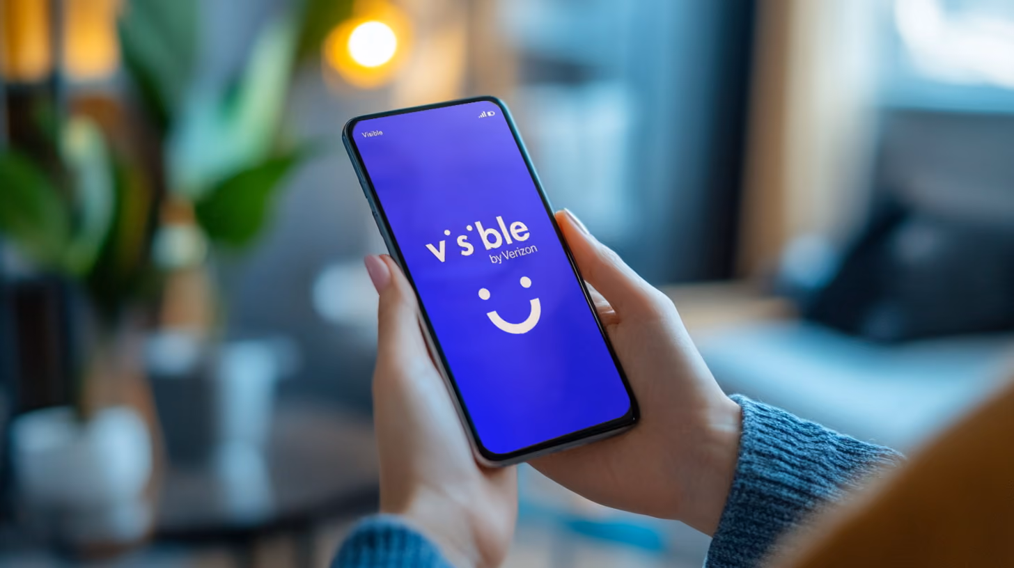 A person holding a phone with visible wireless logo on the screen
