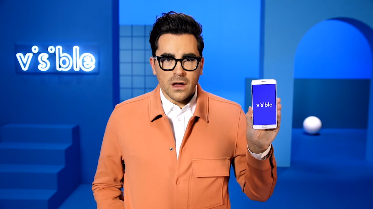 A person holding a smartphone with visible wireless logo on the screen