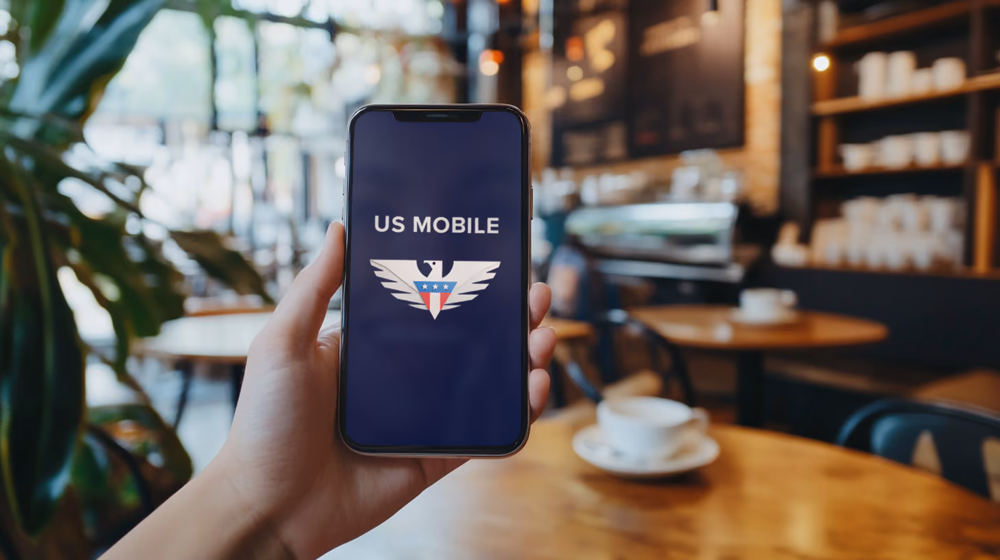 A person holding iphone with US Mobile logo on the screen